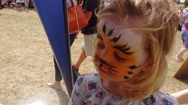Child with face painted to look like a tiger