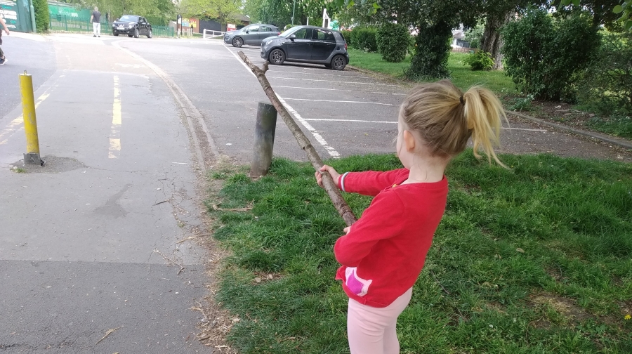 Child holding a stick out in front of themselves